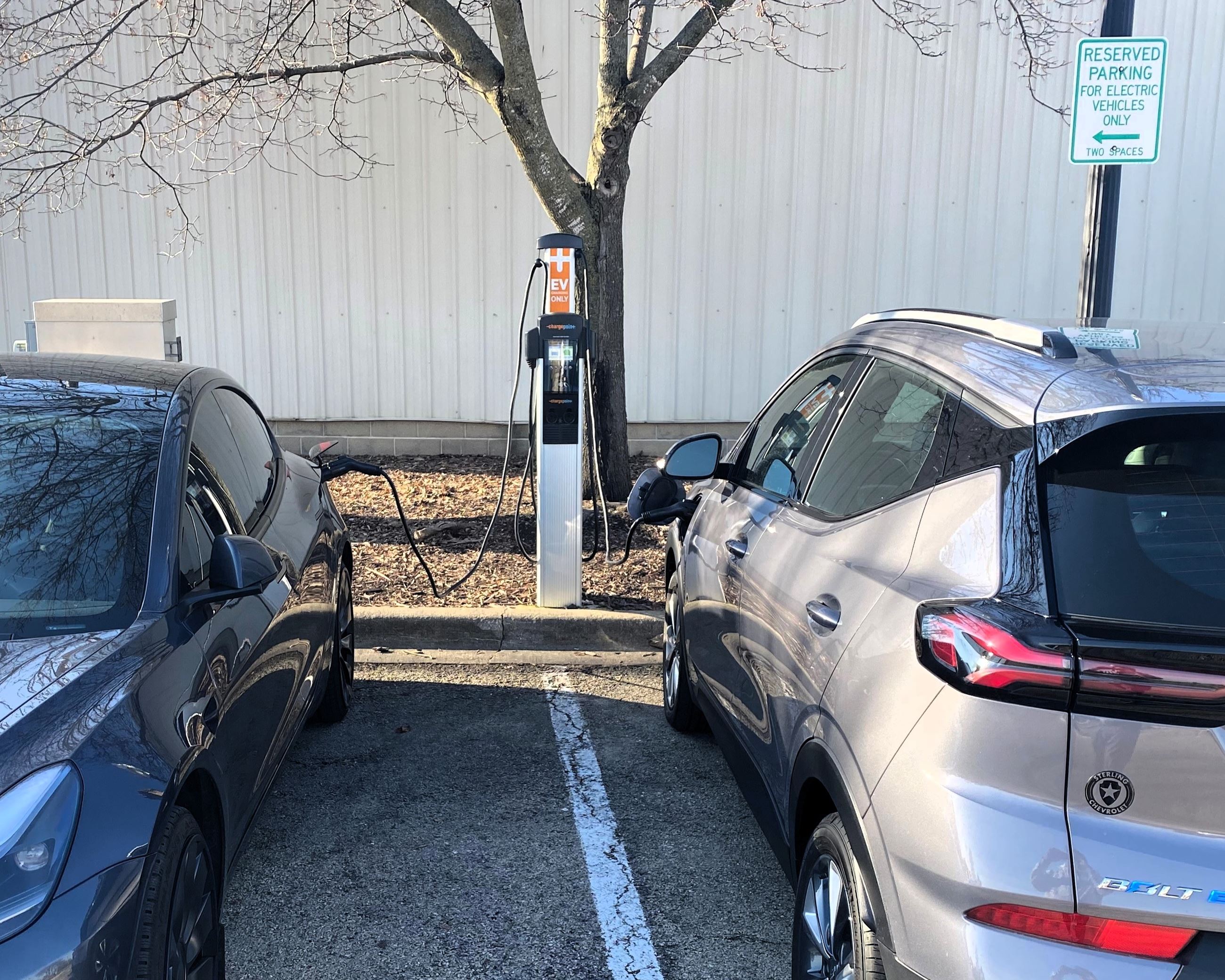 Two vehicles plugged in at the EV charger in the Vaughn Parking Lot